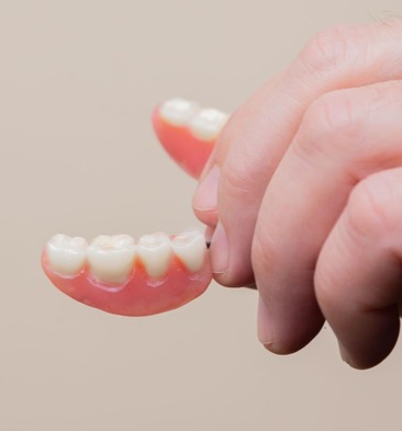 denture hand holding a denture