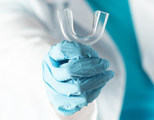 dentist holding a mouth guard